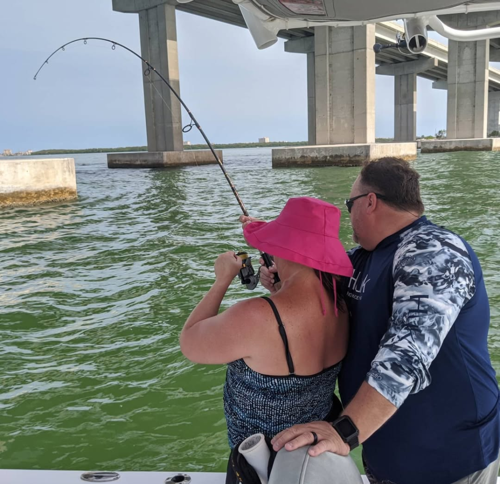 An Aquatic Escapes guest fighting a fish with Captain Jarrod on Tampa Bay