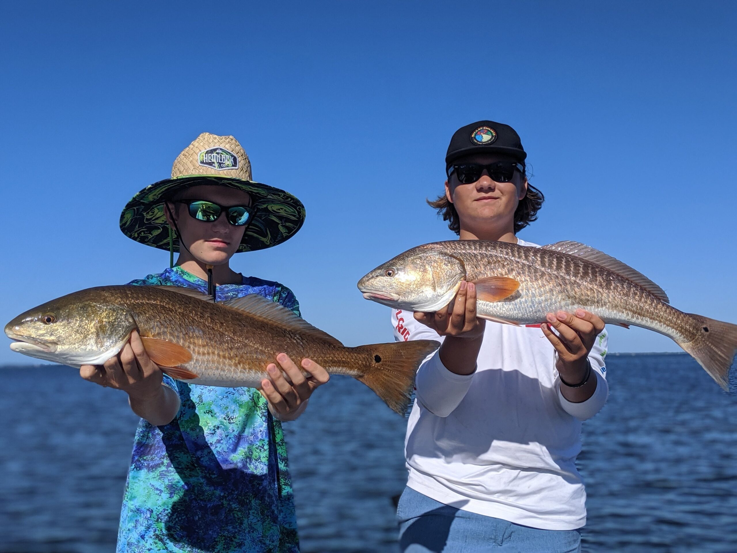Two Aquatic Escapes anglers holding redfish caught on Tampa Bay