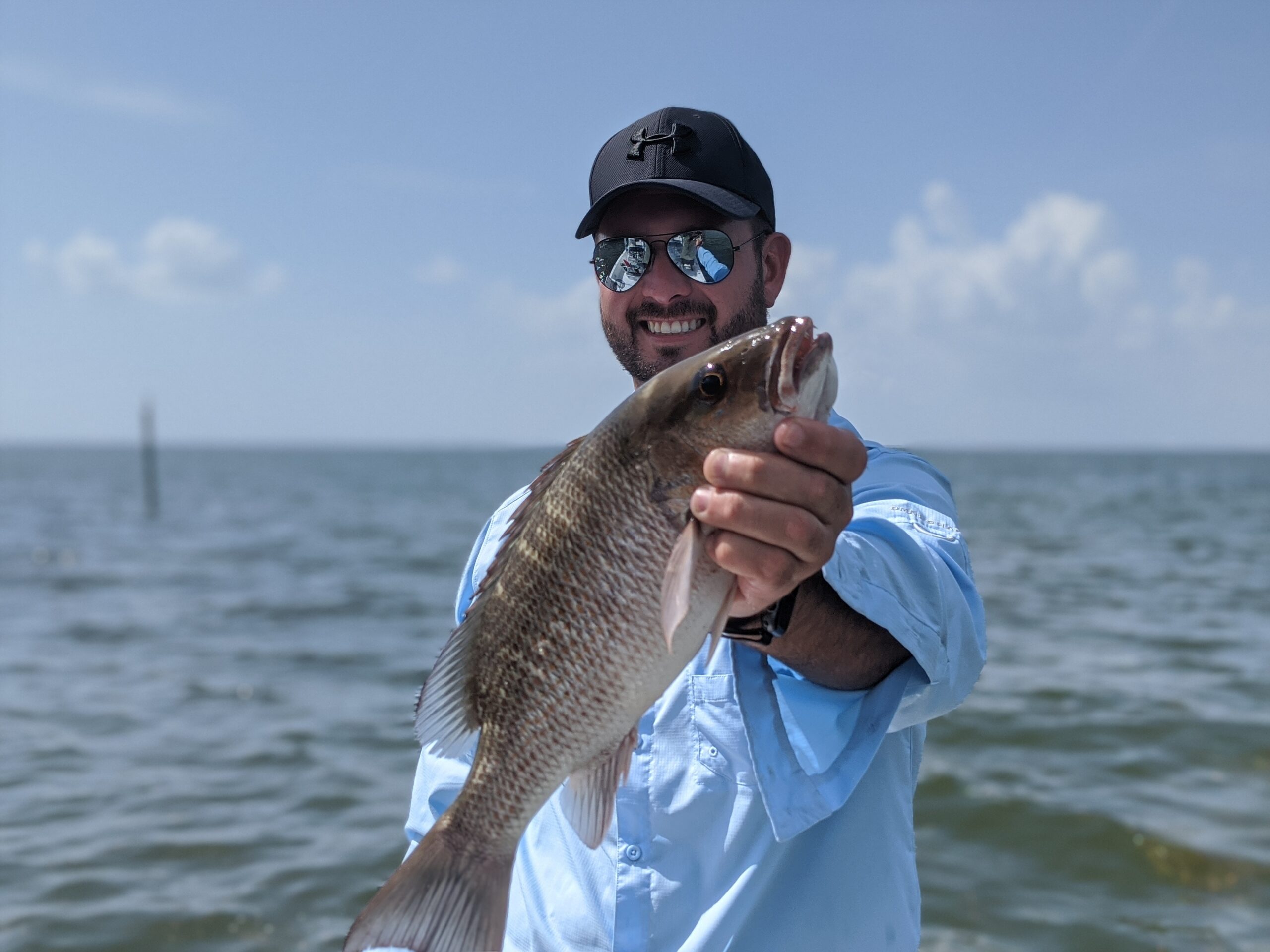An Aquatic Escapes guest holding a redfish caught inshore on Tampa Bay