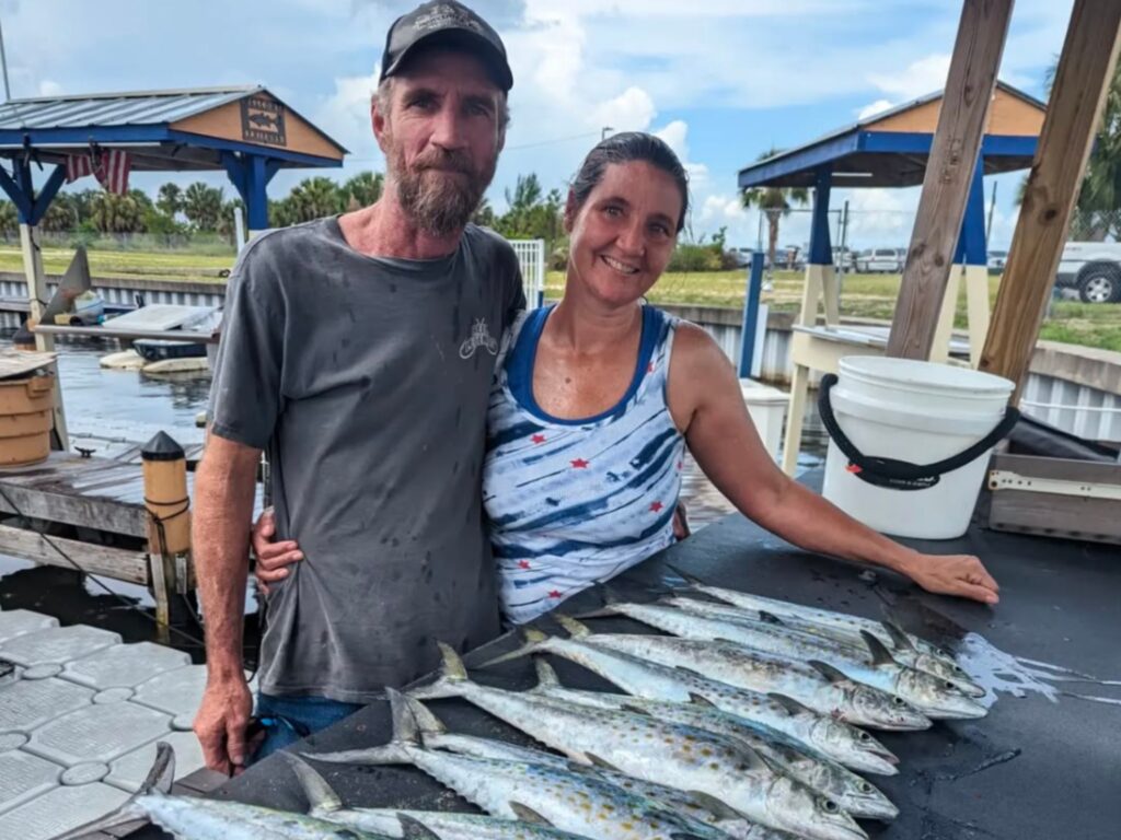 Couple on the dock with a catch of Spanish mackerel after their charter
