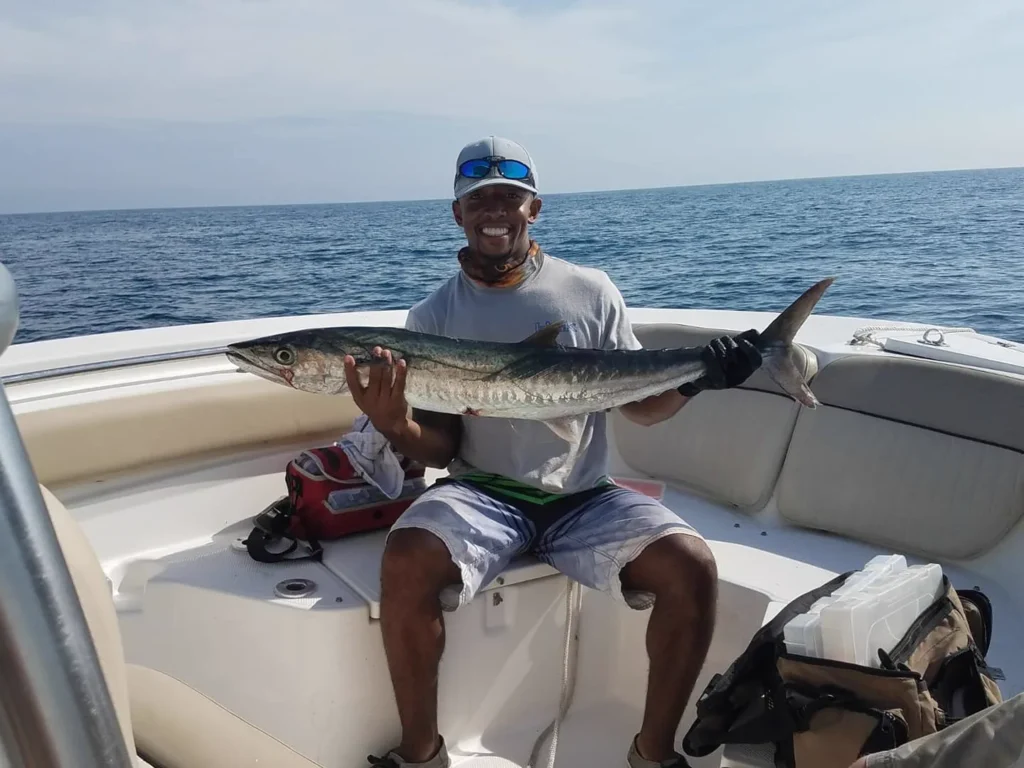 Angler holding a cobia on the deck of the center console