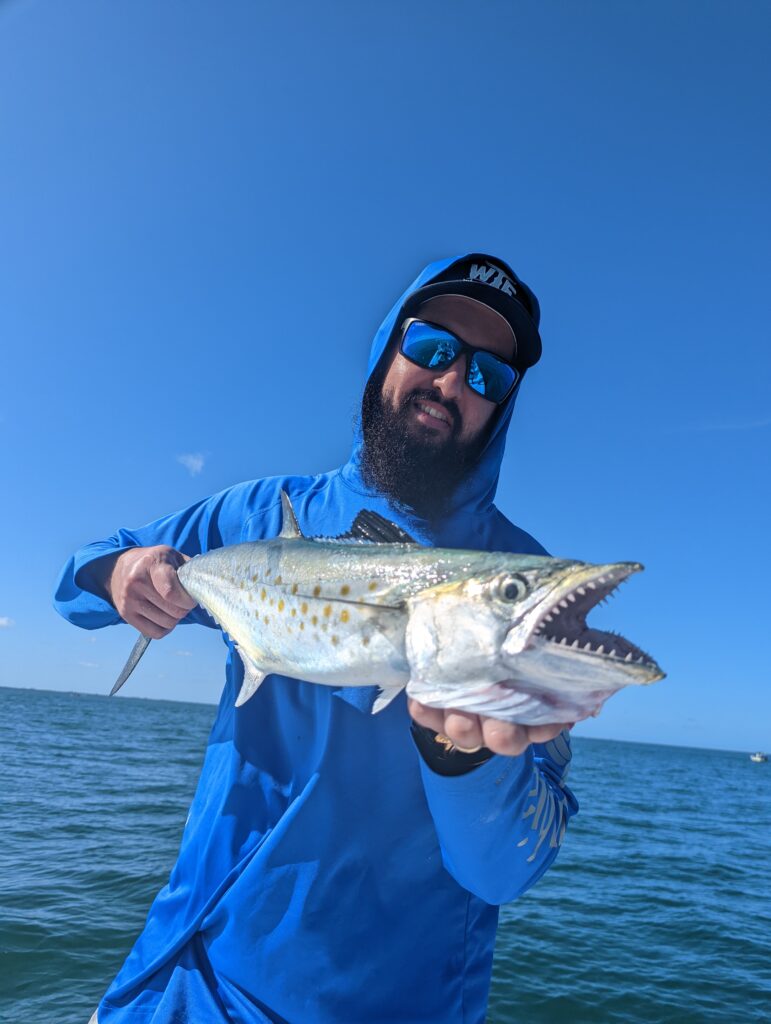 Angler holding a Spanish mackerel on an inshore fishing charter