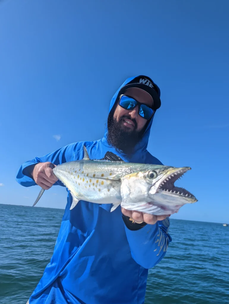 Angler holding a Spanish mackerel on an inshore fishing charter