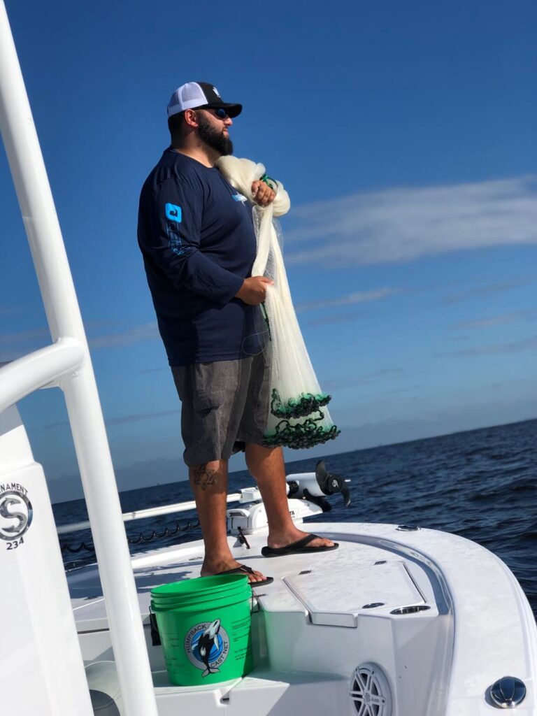 Cast net gathered and ready to throw from the bow of the charter boat
