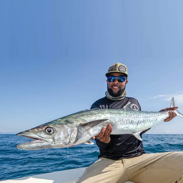 Angler holding a king mackerel in the Gulf of America