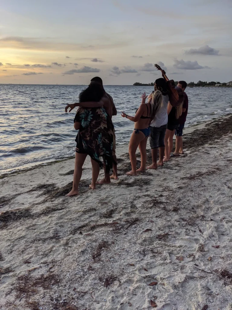Guests on the sandbar at sunset during an island hopping charter