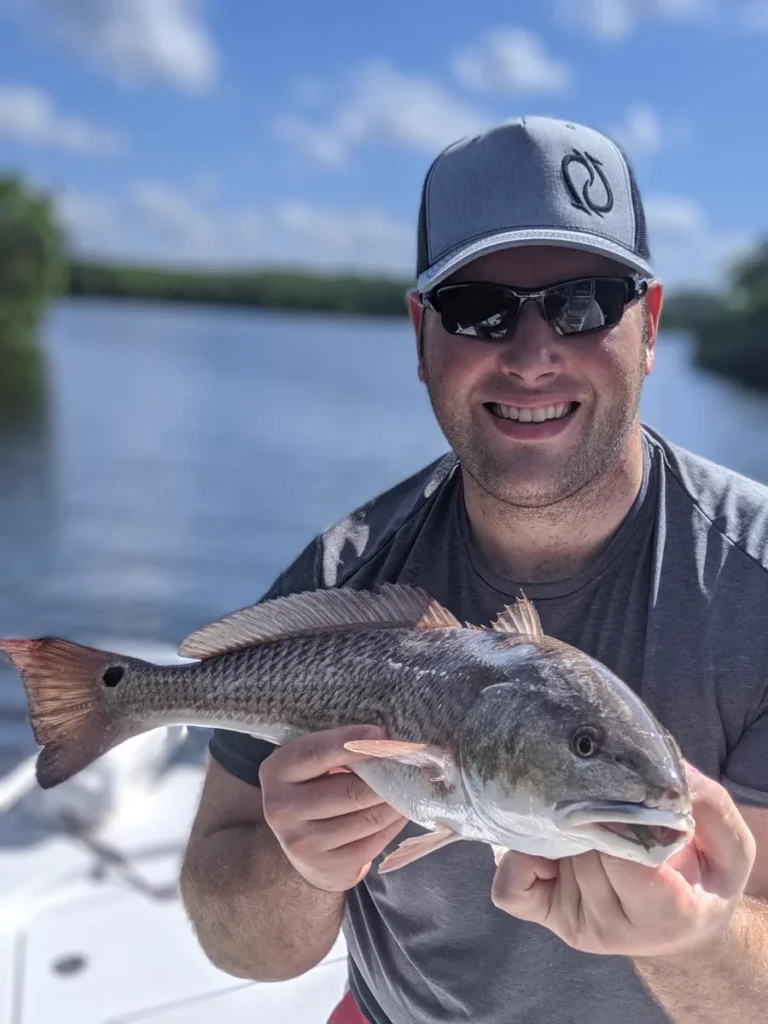 Angler holding a redfish caught on cut bait in Tampa Bay