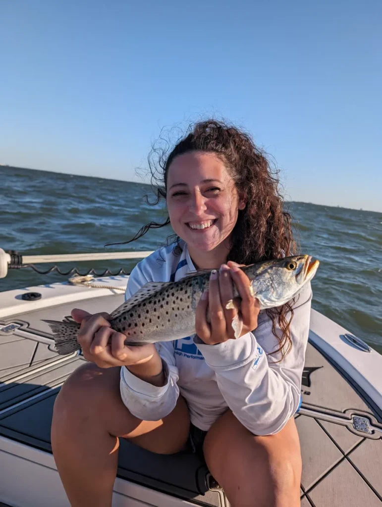Angler holding a spotted speckled trout caught under a popping cork on the Tampa Bay grass flats