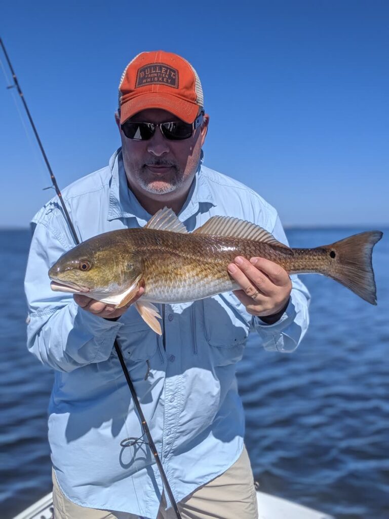 Angler holding a redfish caught on the Tampa Bay flats in October