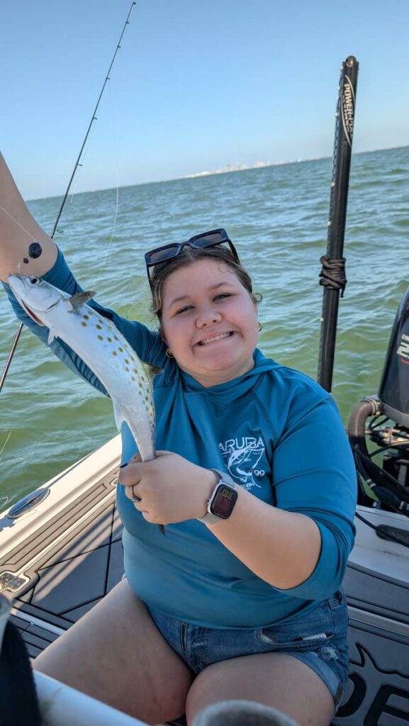 Angler smiling with a speckled trout caught on the Tampa Bay grass flats