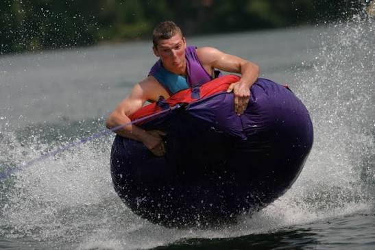 Guest riding an inflatable tube towed behind the boat