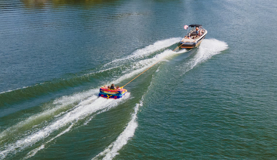 Aerial view of a boat towing riders on an inflatable tube